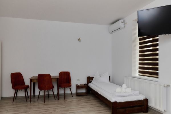 Habitación de Casa Marko con mesa, sillas, TV y aire acondicionado