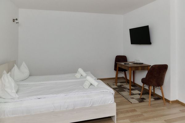 Habitación de Casa Marko con cama doble, TV en la pared, mesa y sillas